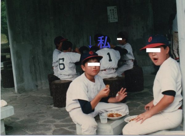 少年野球のお昼休憩時にお弁当を食べている少年の画像