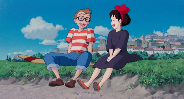 映画「魔女の宅急便」のワンシーンで、トンボとキキが浜辺で座って笑ているシーン