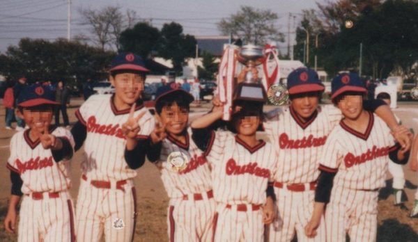 少年野球で優勝カップを持ってチームメイトと写っている画像